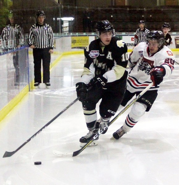 Isaac Saniga tries to take it to the net while Whitecourt defenceman Tanner Foster does his best to slow him down.