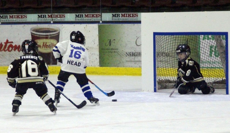 Cooper Ference tries to stop Elijah Head from scoring on a breakaway during a matchup between BMHA and Cold Lake Minor Hockey