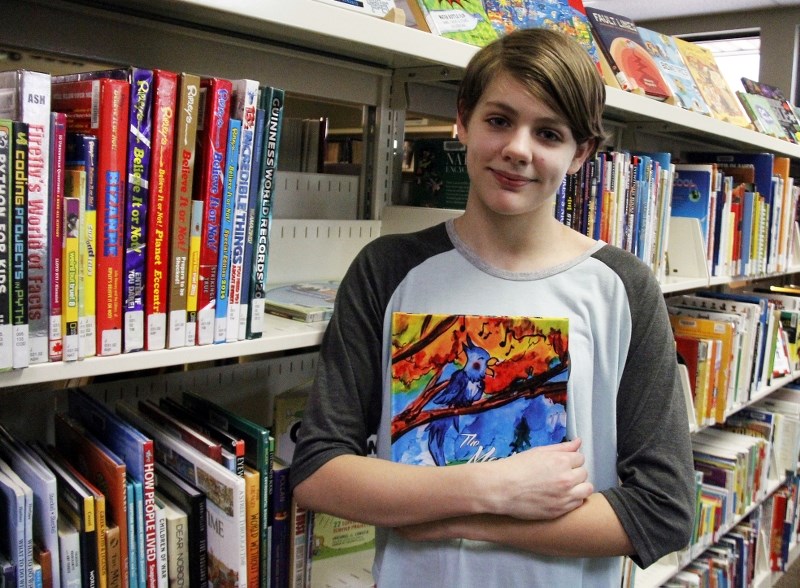 Bonnyville&#8217;s young author Rylie Landry curls-up with her book at the Bonnyville Municipal Library.