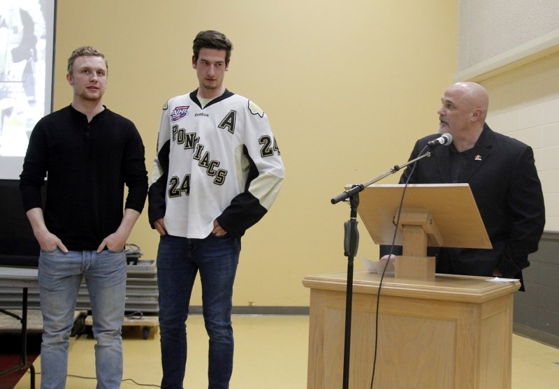 Head coach Rick Swan takes a moment to recognize 20-year-old players captain Charlie Gawlicki and Riley Smith.