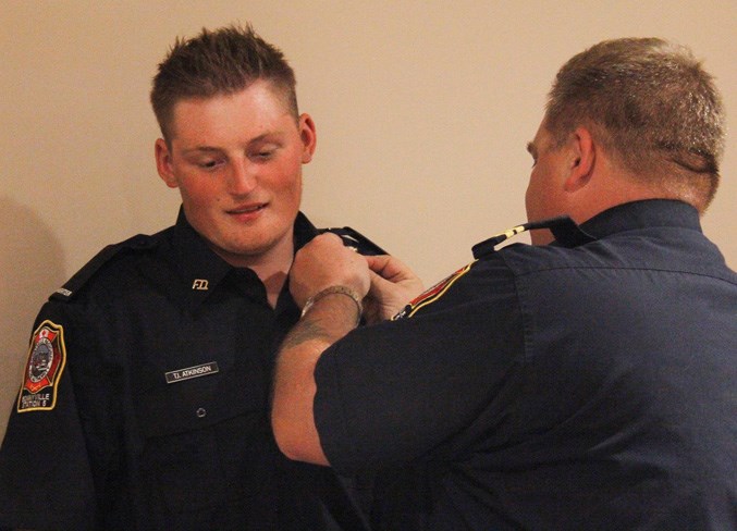  Capt. Dwayne Ethier places the pins on TJ Atkinson's lapels.