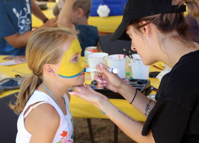  Reighynn Pawlowski gets her face painted as a minion during the duck race activities.