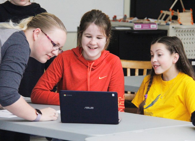  Teacher Amanda Boates gives Grade 6 students Rebekah and Morgan some coding tips.