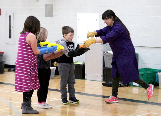  Whitney Horban hands off a balloon animal to Duclos Grade 2 student Ryder Reid to help bring it back to life while Emily Earhart (middle) and Lily Gehrig (left) watch on.