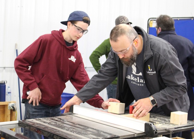  Taking a shot at carpentry is Grade 9 CLHS student Evan Acaessie (left). Lending him a hand is Lakeland College carpentry instructor Trevor Provick.