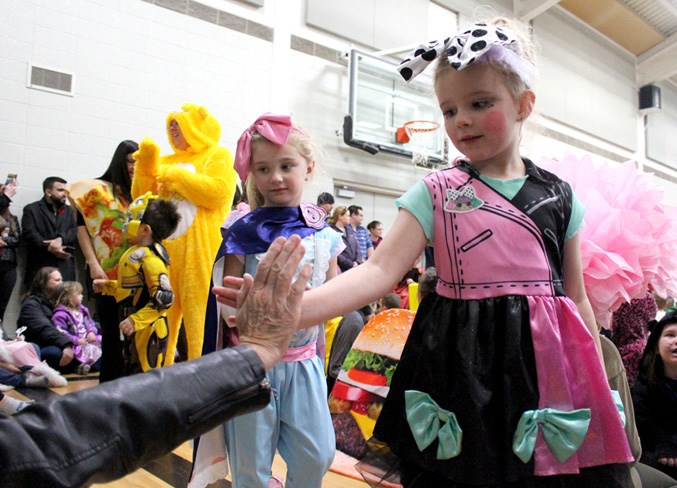  (left to right) Kaybree Herele and Lilly Dawe give out high-fives during the Duclos School Halloween parade on Oct. 31. - Photo by Robynne Henry