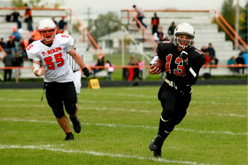 Wayne Fiddler (4), QB for the St. Paul Lions passes off the football during the Lions&#8217; season opener game with the Weslock Thunderbirds on Friday afternoon at the St.