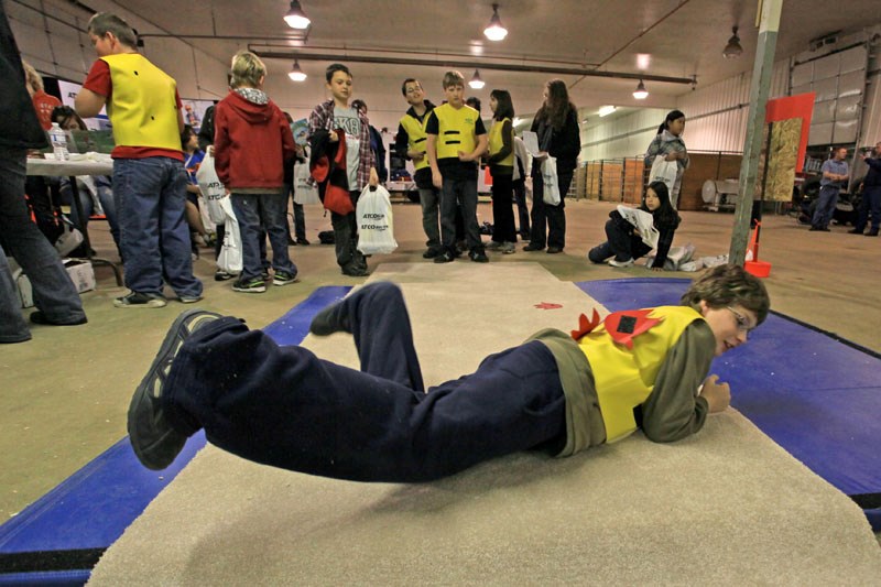 Evan Langager, a Grade 5 student from St. Paul Elementary School tries out a game which demonstrates the drop and roll technique to extinguish flames on one&#8217;s clothing