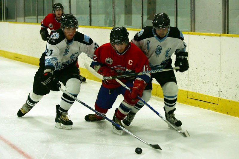 Canadiens Captain Rylan Madoche (12) is guarded by two players from the Cold Lake Ice during the second period of the Canadiens vs. Ice game on Sunday afternoon. The Ice won