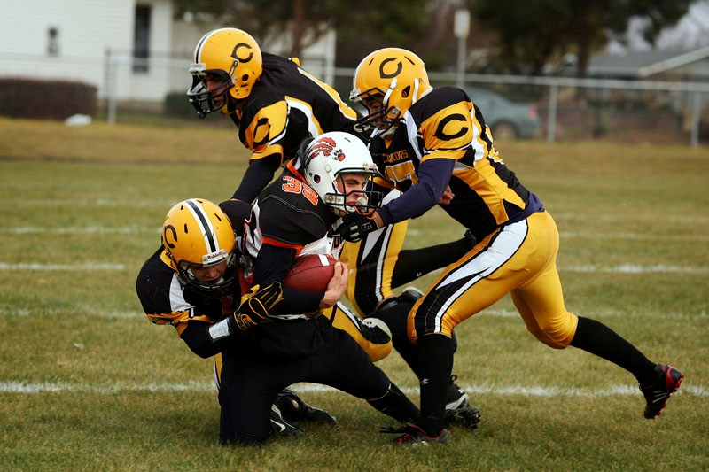Dale Krankowsy (center) is stopped by three Wainwright Commandos during the Lions&#8217; opening playoff game against the Commandos on Friday afternoon. The Lions won by a