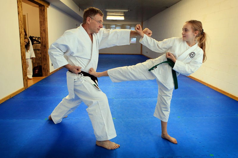 Gemma Pag é, 11, a green belt practitioner of karate, and Calvin Leckie, instructor at the St. Paul Karate-do school show some moves on Thursday evening. Gemma will be