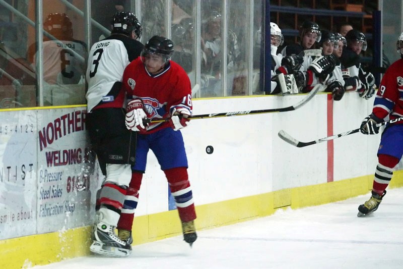 Dustin Oulette (16) of the St. Paul Canadiens checks Jordy Lovig (3) of the Wainwright Bisons in a game at St. Paul last Saturday evening. The Canadiens lost by a score of