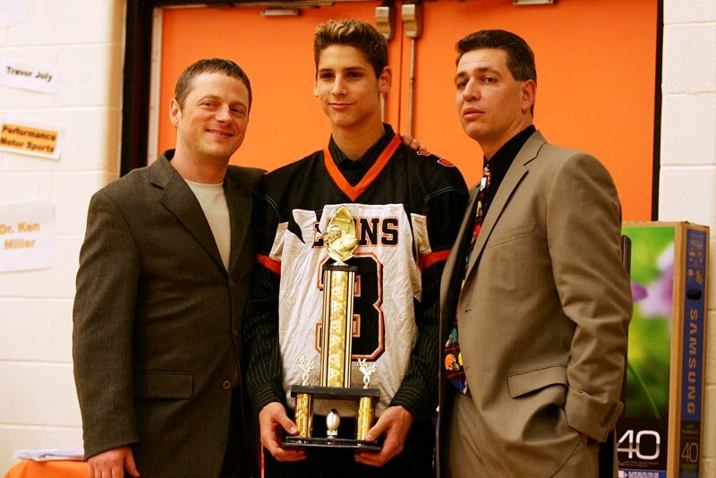 Coach John Lumby, player Mark Proskiw and Coach Todd Tanasichuk pose for a photo after Proskiw wins the Lions&#8217; MVP award during the St. Paul football awards night at