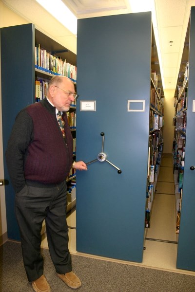 Northern Lights Library System director Mircea Panciuk demonstrates the massive mobile shelving units that travel on tracks set in the floor to offer up to 80 per cent more