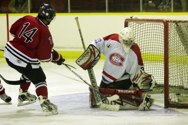 Jared Cunningham (14) of the Saddle Lake Warriors scores on the St. Paul Canadiens&#8217; goalie, Evan Joly, on Friday evening at Saddle Lake arena. The Warriors won bya