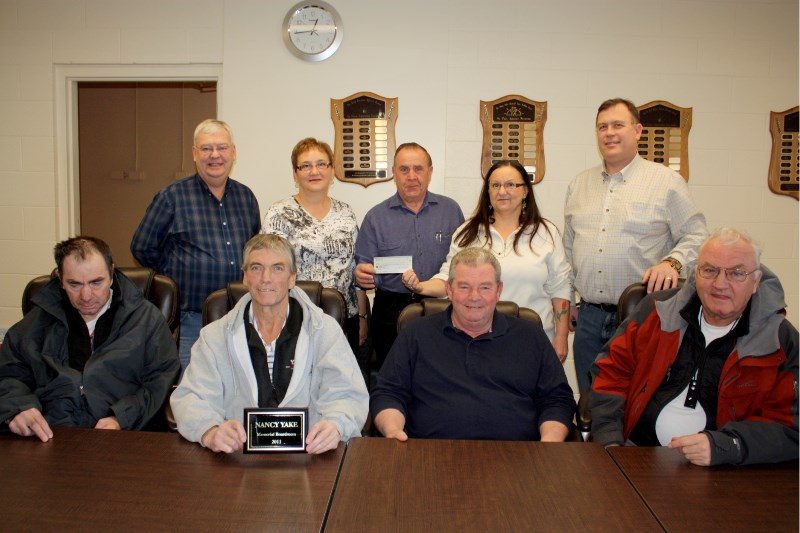 The Yake family gathers with SPAN board members in the meeting room which is dedicated to the memory of their mother Nancy Yake. Greg (front left), Nelson, Dan and David.