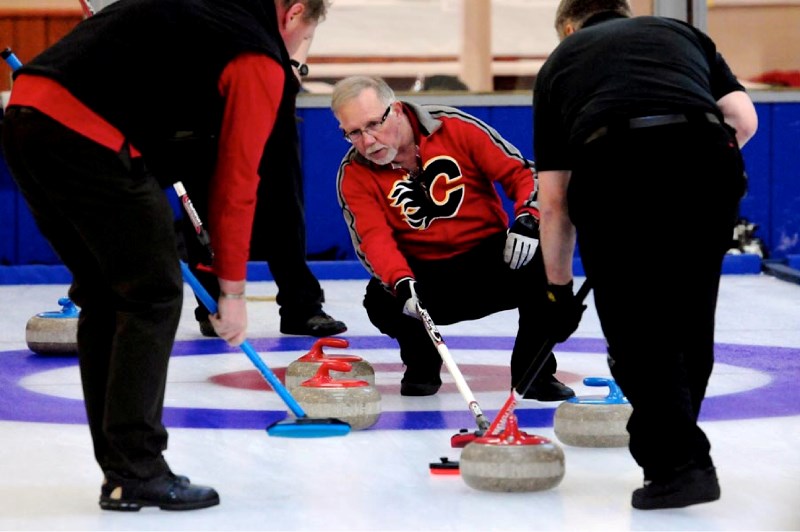Dan &#8216;the bottle man&#8217; Bojarski surveys a shot during his team&#8217;s match at the St. Paul curling rink on March 19.