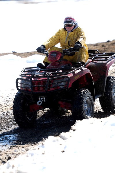 A quad driver navigates through a puddle during the Ashmont Quad Rally on Saturday.