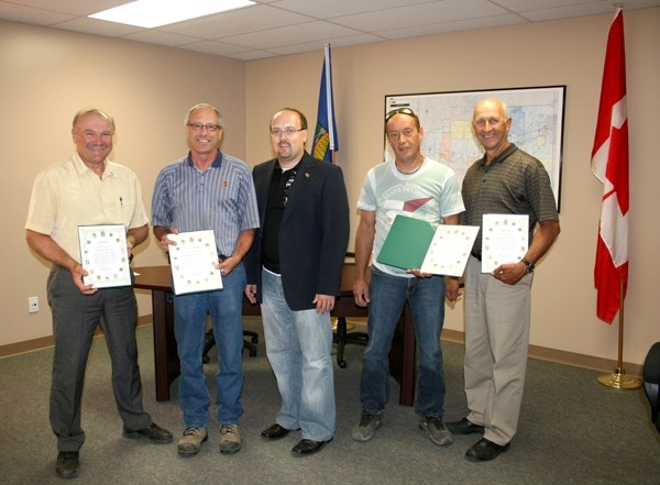 Darryl Poirier (left), Denis Levasseur, Luc Gascon and Danny Smyl received recognition from MP Brian Storseth (centre) for their contributions to the Slave Lake relief effort 