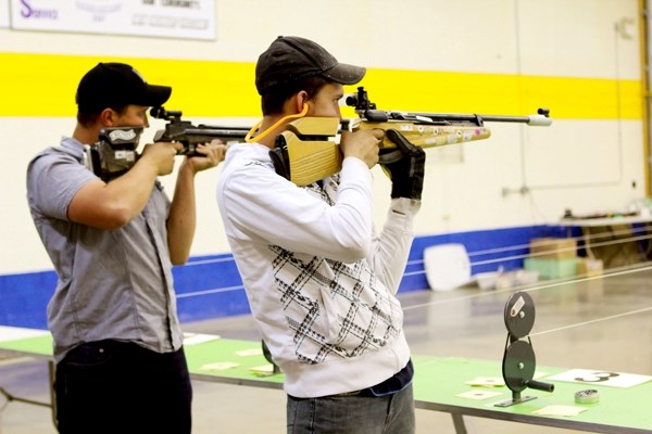 Chad Stark (right) concentrates on taking a shot, while fellow local air rifle competitor Randon Stark, does the same at the annual Eldorado Air Gun Match at the curling rink 