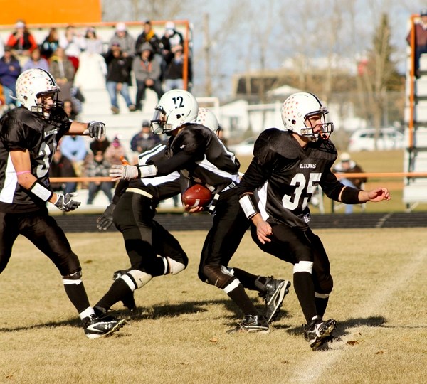 Quarterback Brendan McKay passes off to Dale Krankowsky as Josh Pelham blocks as the St. Paul Lions took on the Lloydminster Barons in Wheatland Football League playoff