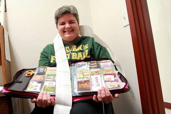 Therese Poitras shows off one of her binders filled with coupons with a long receipt, detailing a successful shopping trip thanks to coupons.