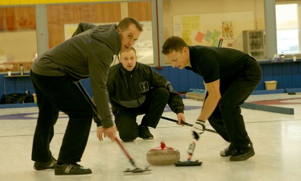 Skip Aaron Bartling watches closely as sweepers AJ Rankel and Cory Henderson clear the ice for the rock in the final game of the Alberta Firefighters Championship Bonspiel at 