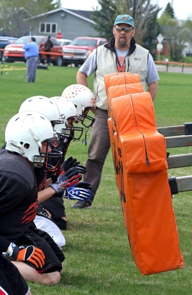 Coach Steve Johnson watches as his players prepare to hit the bags at spring training for the St. Paul Lions last week. The team will host a jamboree this weekend against