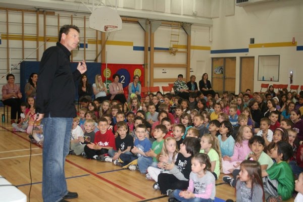 Author Sigmund Brouwer listens to hear if St. Paul Elementary School students are singing along to the music blasting through the gym. Brouwer visited the school on May 24