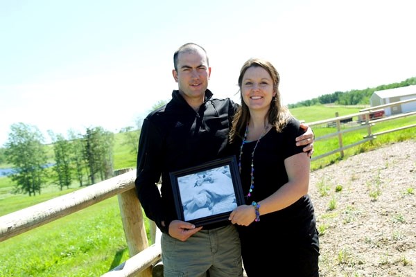 Adam and Crystal Charbonneau hold a picture of their son Caleb James, who was born with anencephaly and only lived for a couple of hours after birth. The couple is now