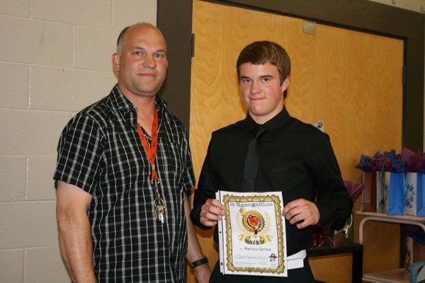 Racette School athletic director Gilles Gervais presents this year&#8217;s male athlete of the year award to Grade 9 student Matthew Gervais.