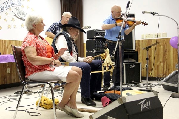 Simone Marshall (left) plays the spoons, while Roy Scott makes a doll dance at last week&#8217;s Heritage Festival at the St. Paul Senior Citizens Centre. Also pictured are