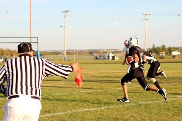 Lions quarterback Brenden McKay returns an interception to within 10 yards of the end zone while the referee throws a flag on the play against St. Paul. The ball was brought