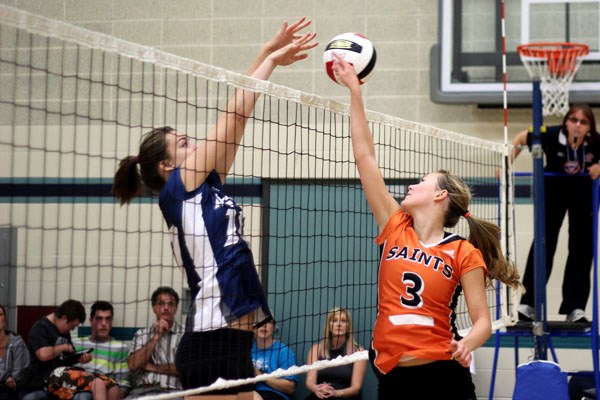 Krista Yacyshyn of the St. Paul Regional High School Saints feathers the ball over the net in a joust during a round robin match against the Assumption Crusaders during the