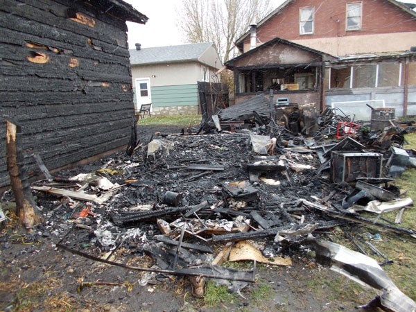 An Oct. 20 fire laid waste to a holiday trailer and shed at a house on 50th Street, damaging a neighbouring garage (left) and the car port adjacent to the main residence (at