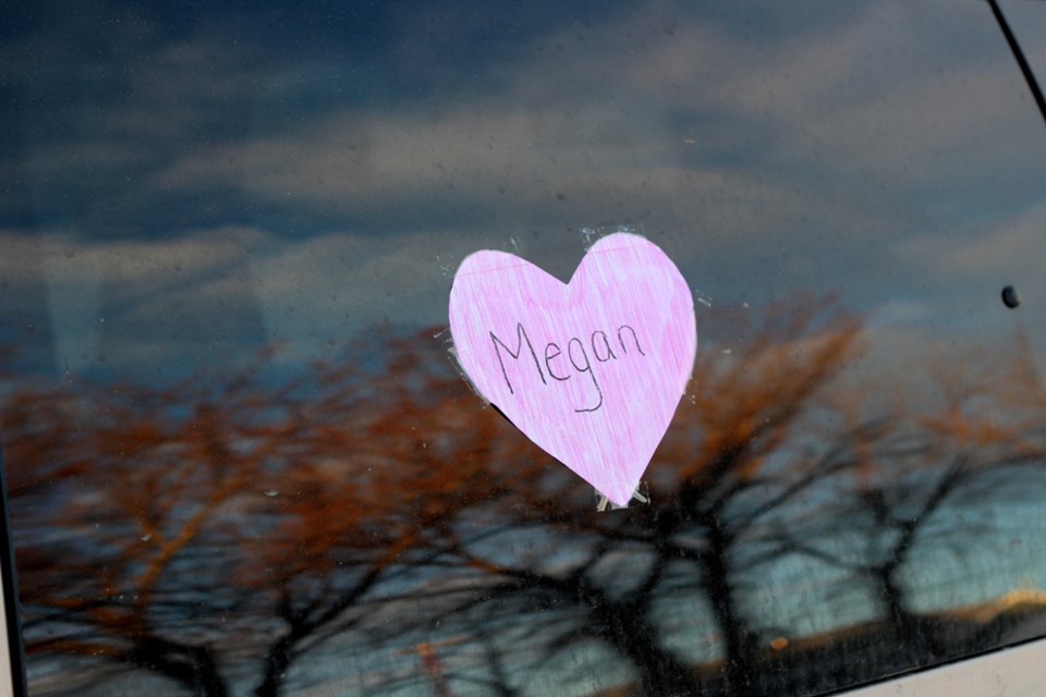 A pink heart is posted to the window of a vehicle in St. Paul in memory of Megan Wolitski.