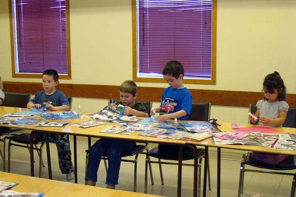 Kids at Ashmont Moms and Tots participate in a Christmas-themed activity as they cut out pictures of toys for their wishlist last Wednesday morning.