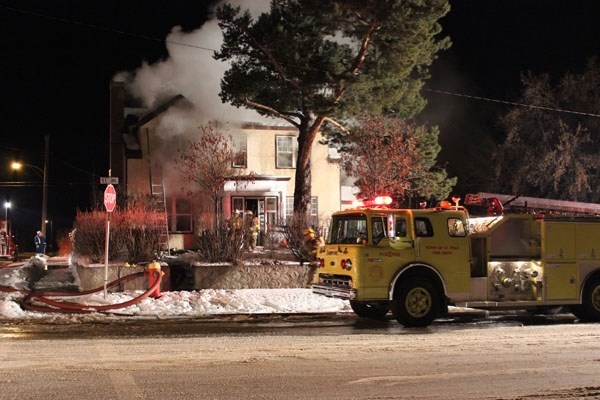 Firefighters work to stop a blaze from spreading at a St. Paul residence on Saturday evening. The fire burned well into the night and resulted in the destruction of the