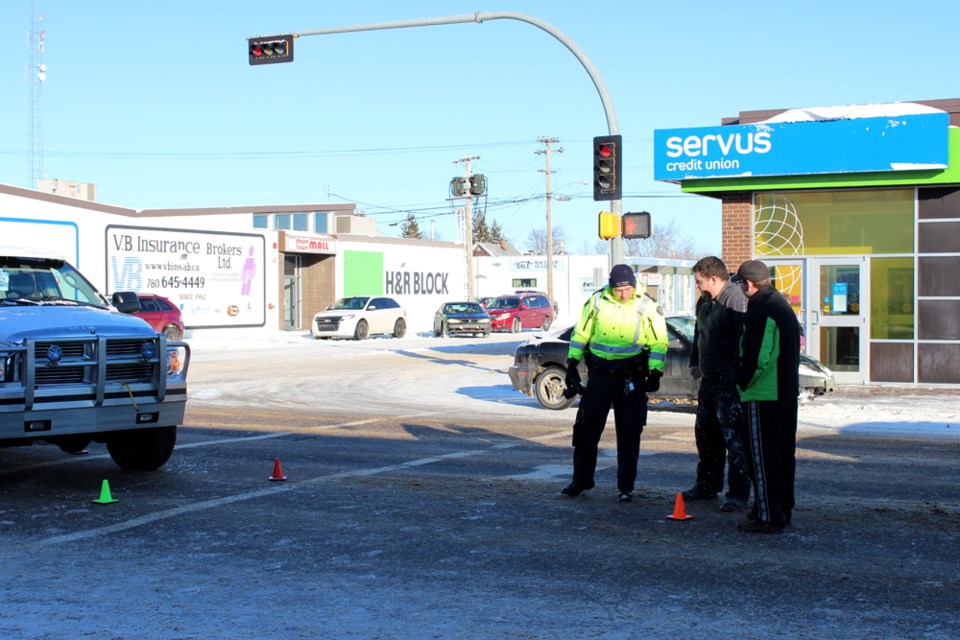 RCMP Collision Analyst Cpl. Jarrett Hughes speaks with witnesses following a fatal pedestrian collision on Feb. 14, in St. Paul.