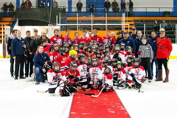 All the Timbits hockey players and their coaches gathered at center ice at the end of the future all-stars game.