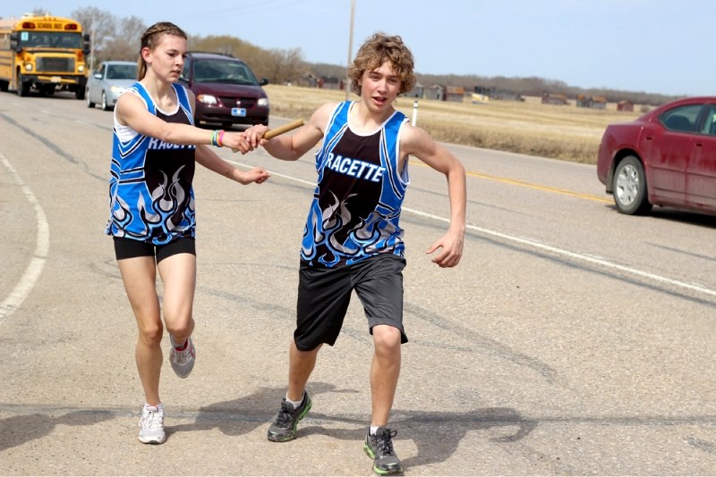 Racette athlete Madisyn Trottier passes the baton to teammate Brenden Foote at the RCMP Road Race mile six exchange point at the Lafond turnoff on Highway 29.