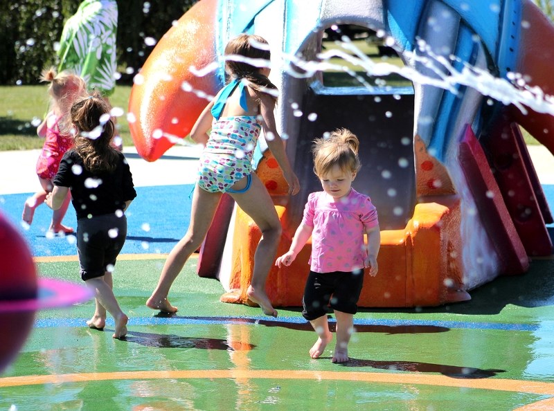 Elizabeth Anderson (pink) enjoys the new splash park in St. Paul, following a grand opening ceremony and celebration that took place on Saturday.