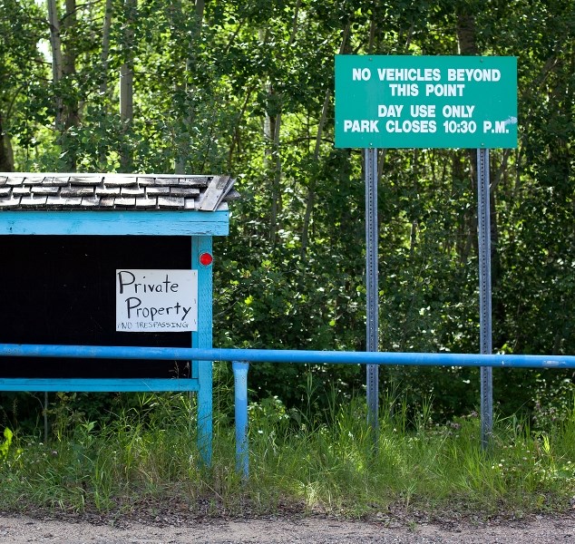 A newly posted &#8220;Private Property&#8221; sign sits next to a &#8220;Day use only&#8221; sign near the main access to the beach area at Lottie Lake. The property