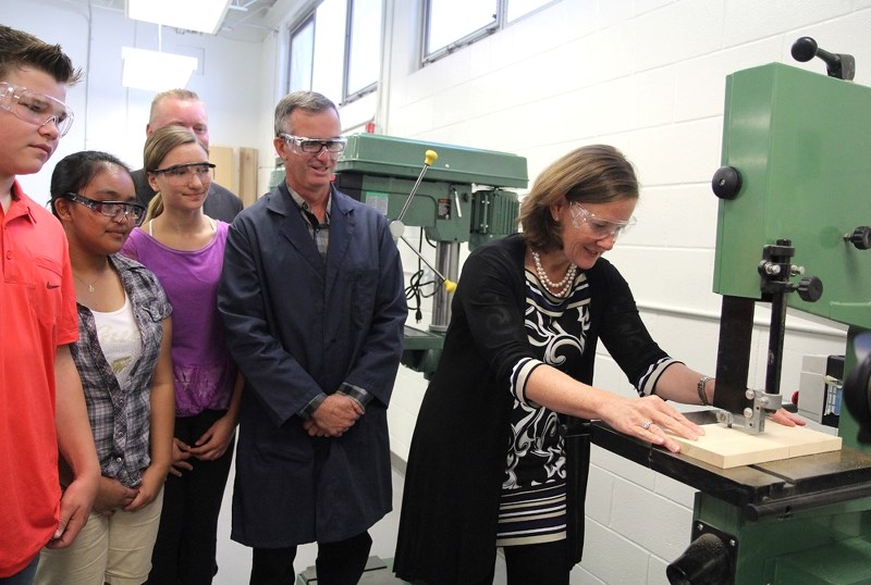 Premier Alison Redford (right) cuts a piece of wood in the newly modernized Racette School shop class, Sept. 4. Redford was on hand during the schools re-opening ceremonies.
