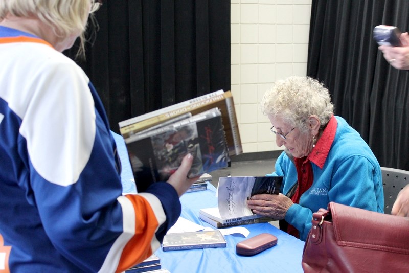Holocaust survivor Eva Olsson signs copies of her books following a presentation at Glen Avon last Thursday.