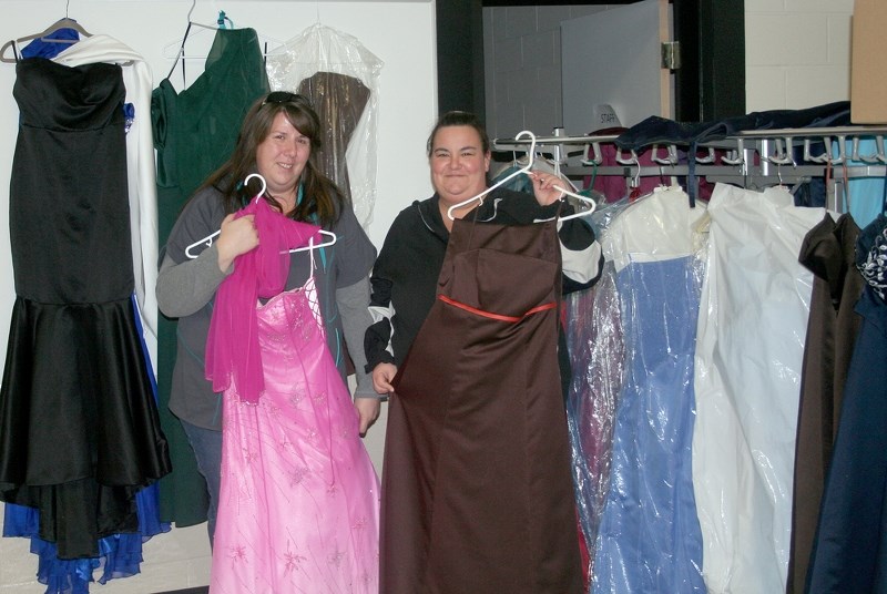 Angele Theroux (left) and Tina Robinson display some of the dresses available through the Dressed to the Nines program. The clothing collection is taking place to help ensure 
