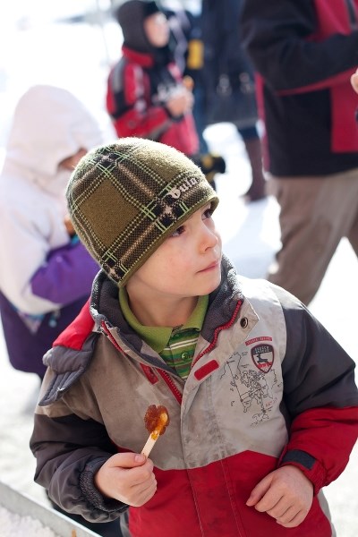 A young boy enjoys taffy on a stick at last year&#8217;s Cabane &agrave; Sucre event, hosted by the St. Paul French Association. Similar events will be taking place this