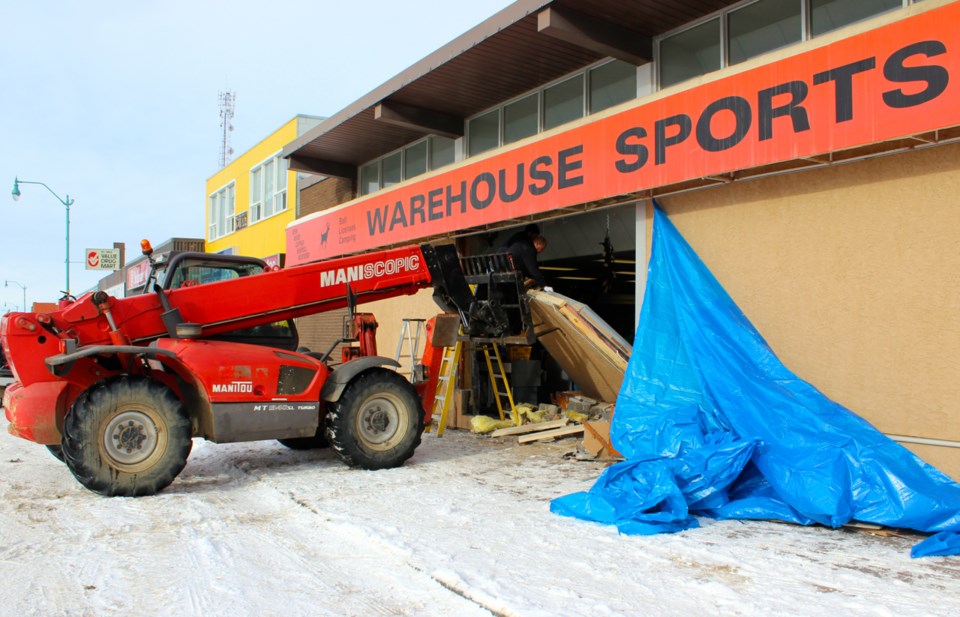 Crews work to repair the damages caused after a truck backed into Warehouse Sports on main street, just after 4 a.m. on Monday morning. Nine handguns were stolen from the