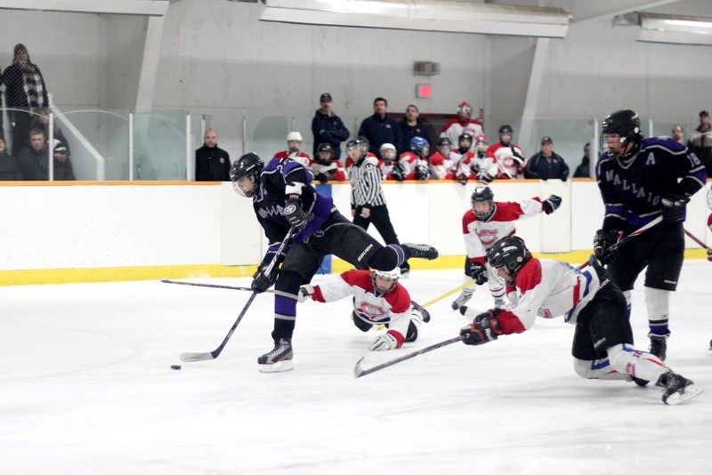 Mallaig Bantam Monarchs Captain Clay Kwiatkowski fires a puck on goal while two St. Paul Canadiens sprawl out in an attempt to prevent the shot, during Game 2 of a provincial 