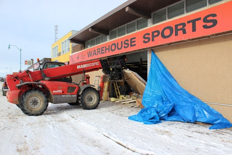 Crews work to repair the damages caused after a truck backed into Warehouse Sports on main street, just after 4 a.m. on Monday morning. Nine handguns were stolen from the